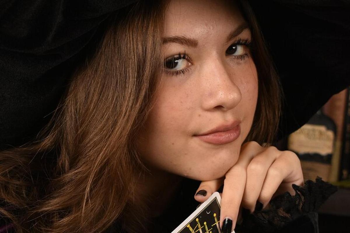 a woman wearing a black hat holding a cell phone