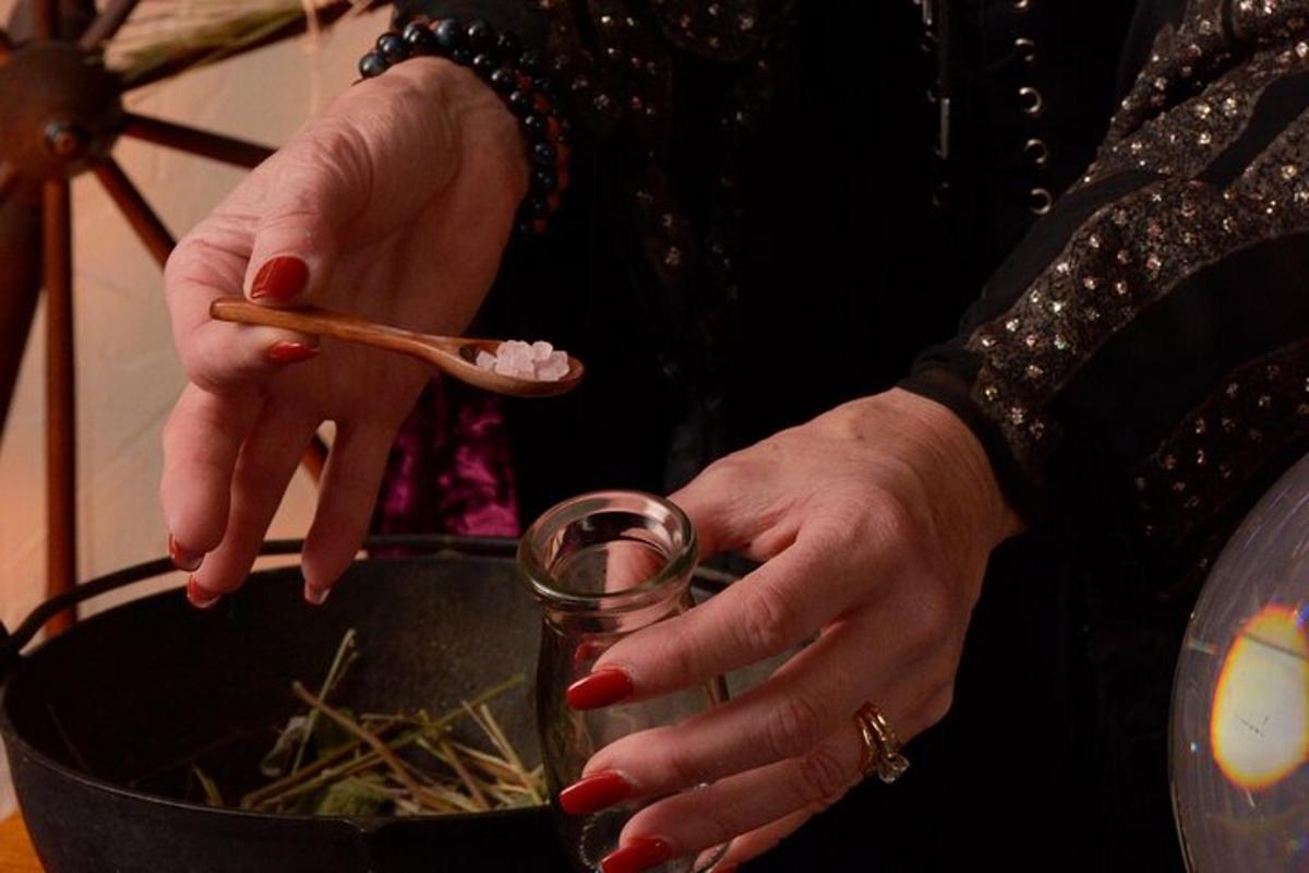 a woman holding a wooden chopstick and a pot of food