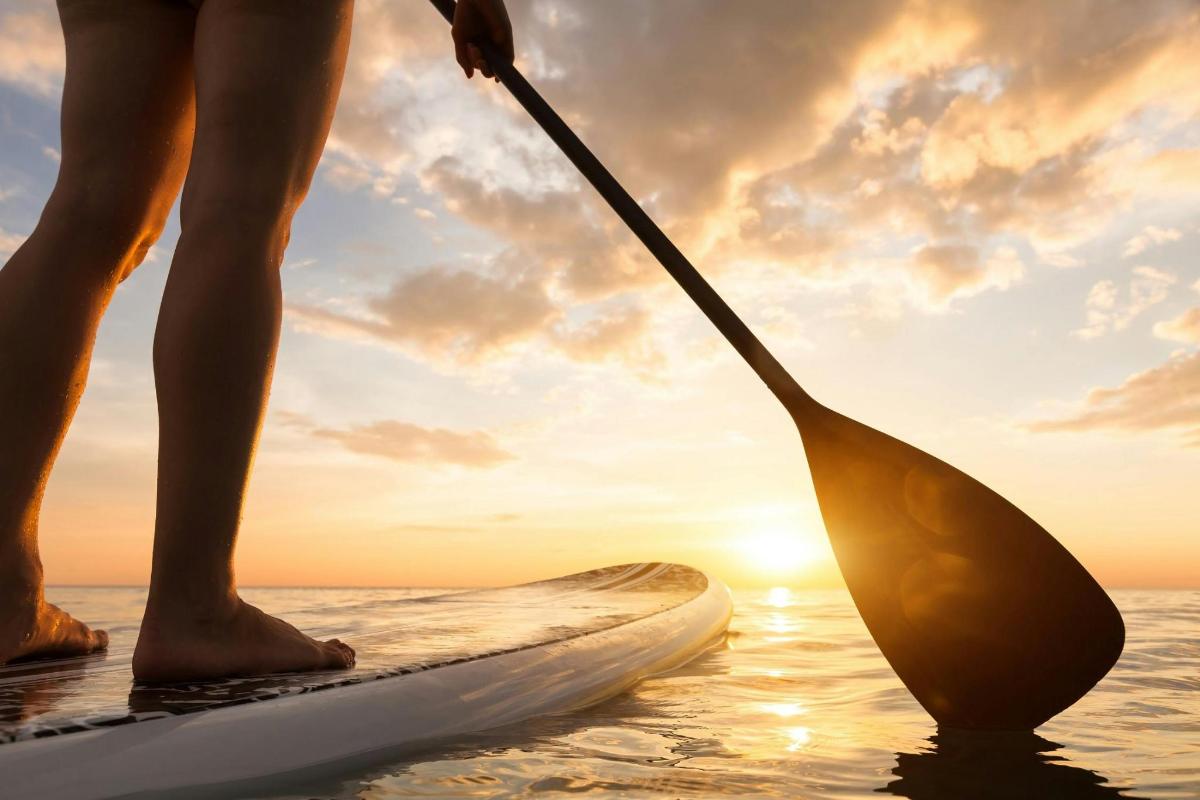 a person standing on a paddle board in the water