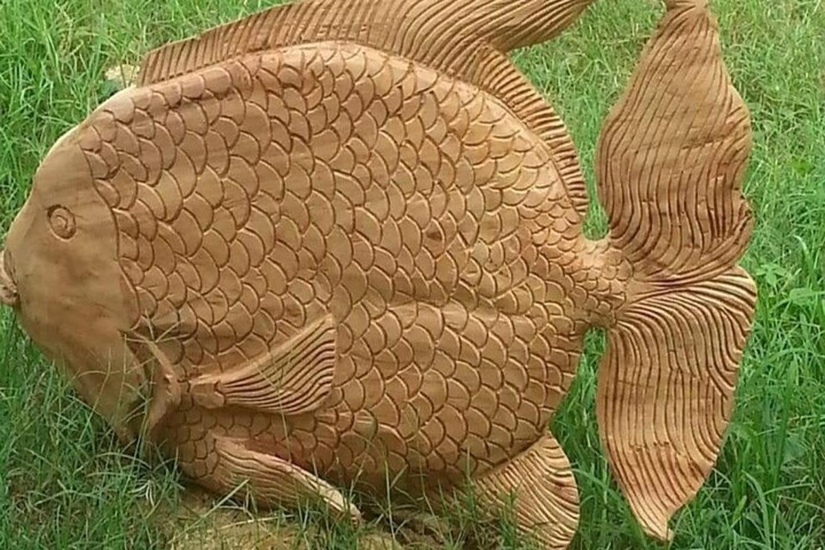 a statue of a fish in the grass