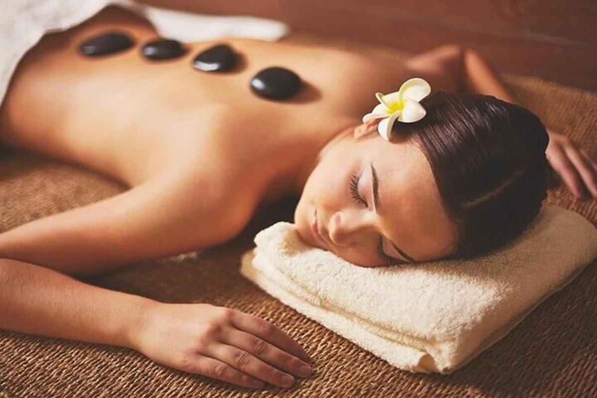 a woman laying on a towel with a flower on her head