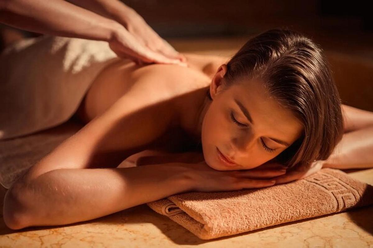 a woman laying on a towel while getting a massage