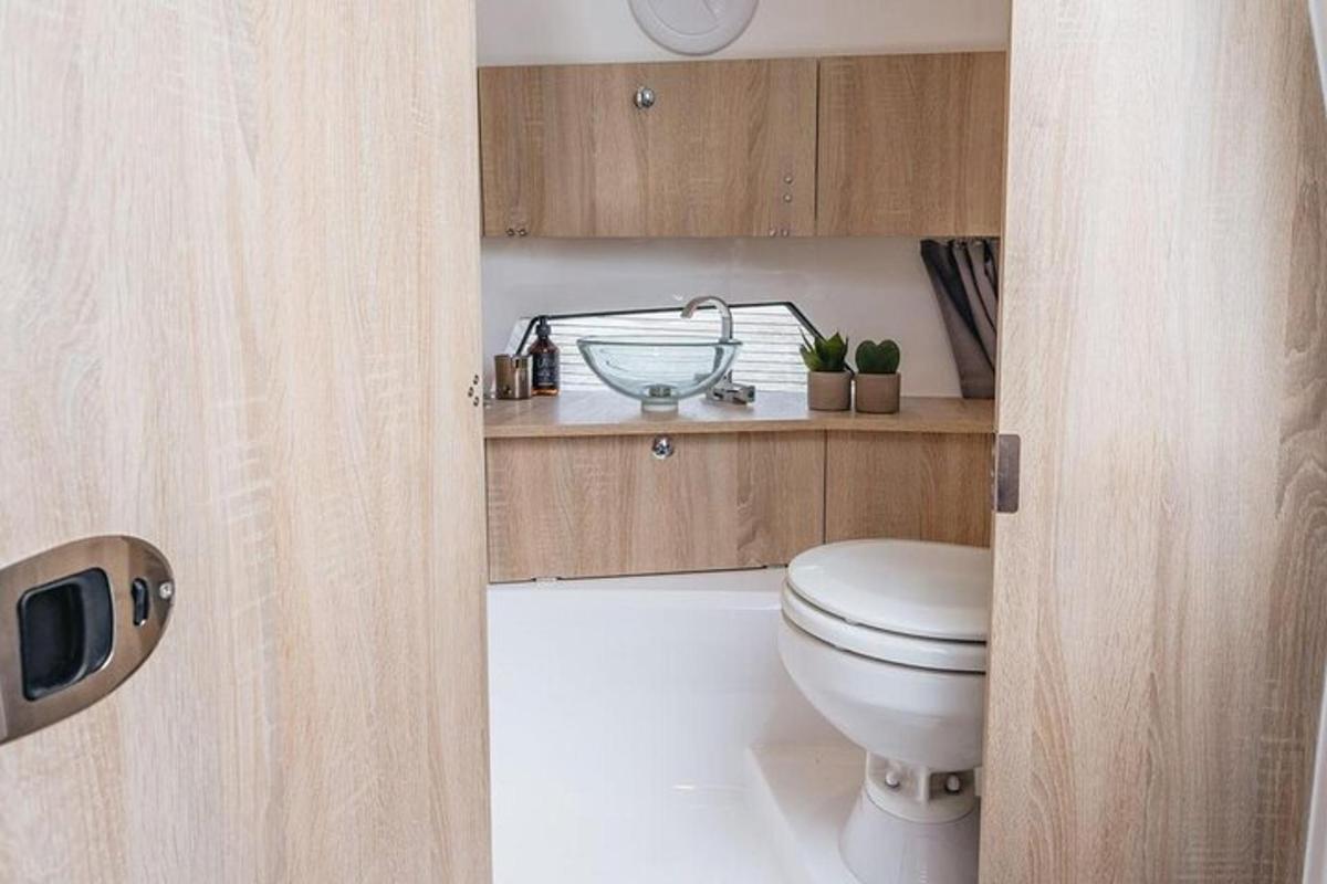 Un baño con inodoro y armarios de madera.