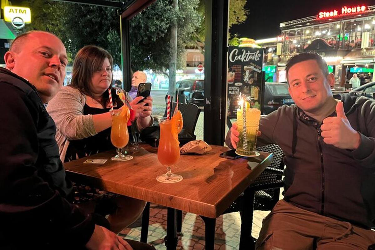 um grupo de pessoas sentadas à mesa com bebidas