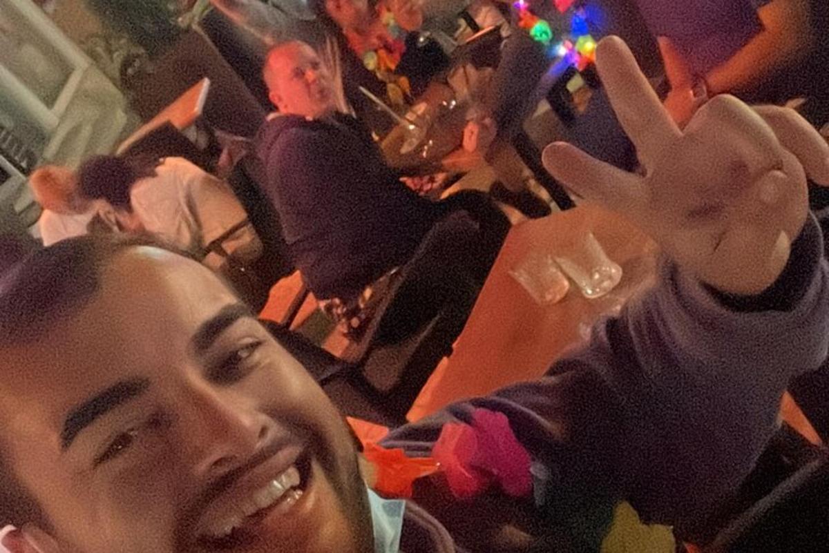 um homem segurando um sinal de paz em um restaurante