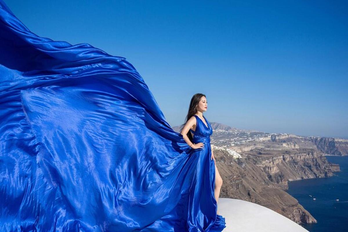 eine Frau in einem blauen Kleid steht auf einem Berggipfel