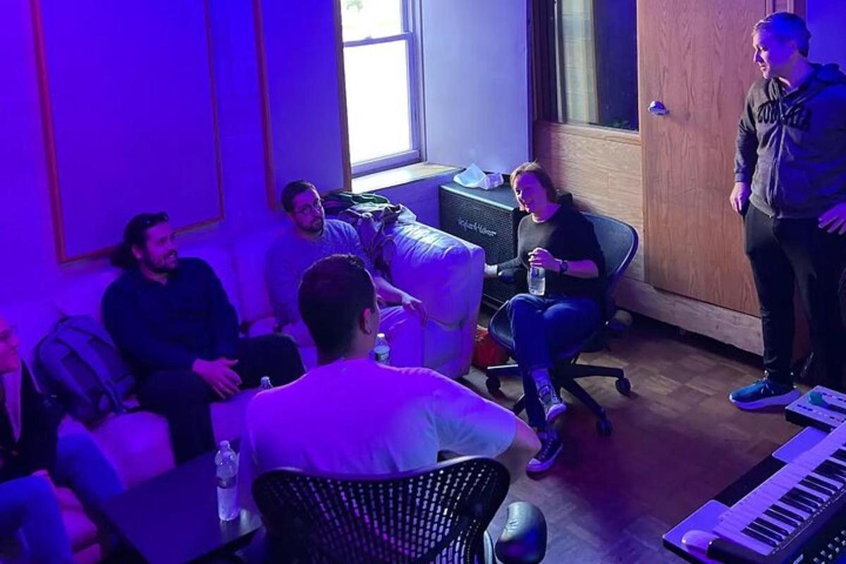 a group of people sitting in a room with purple lighting
