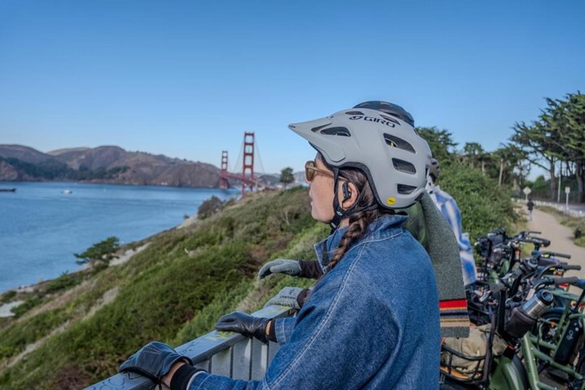 a woman with a helmet sitting on a fence