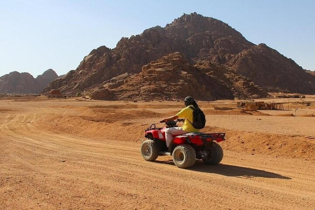 شخص يركب دراجة رباعية في الصحراء