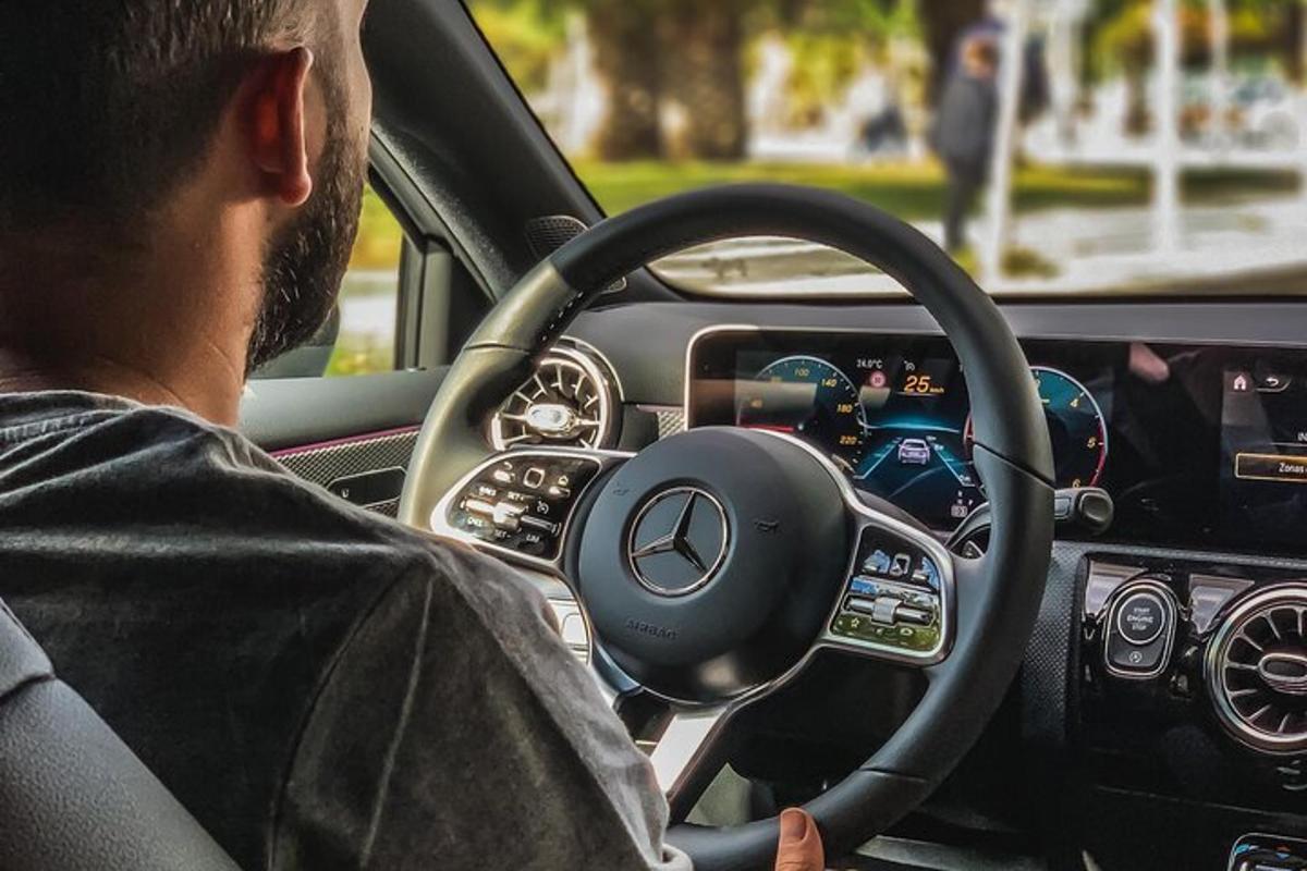 un hombre conduciendo un coche con un volante