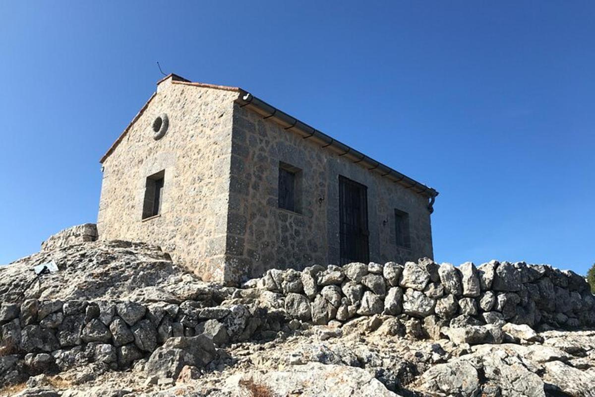 un antic edifici de pedra al cim d'un turó rocós