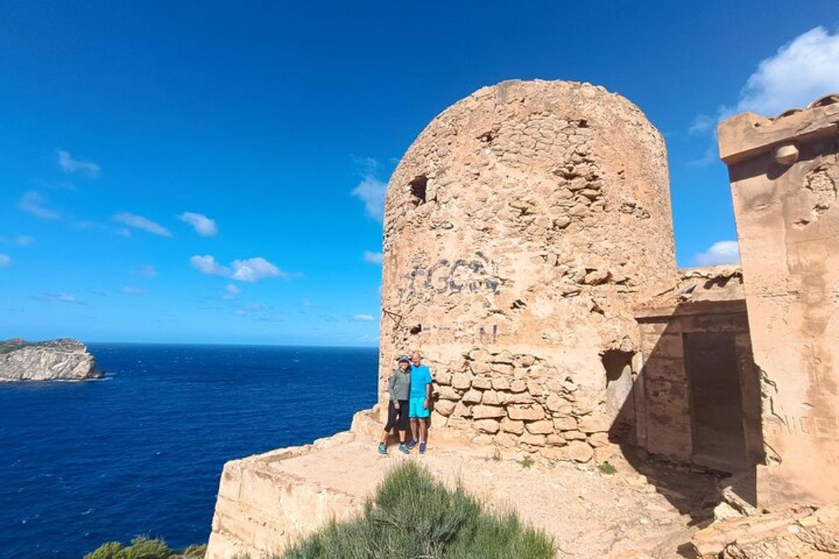 un home dret a la vora d'un mur de pedra prop de l'oceà