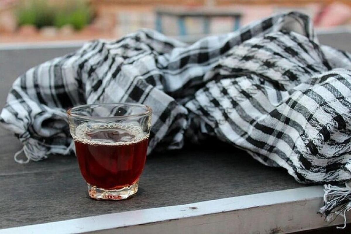 ένα ποτήρι αναψυκτικό κάθεται σε ένα τραπέζι με μια κουβέρτα