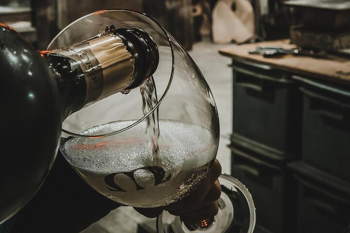 a person pouring wine into a wine glass