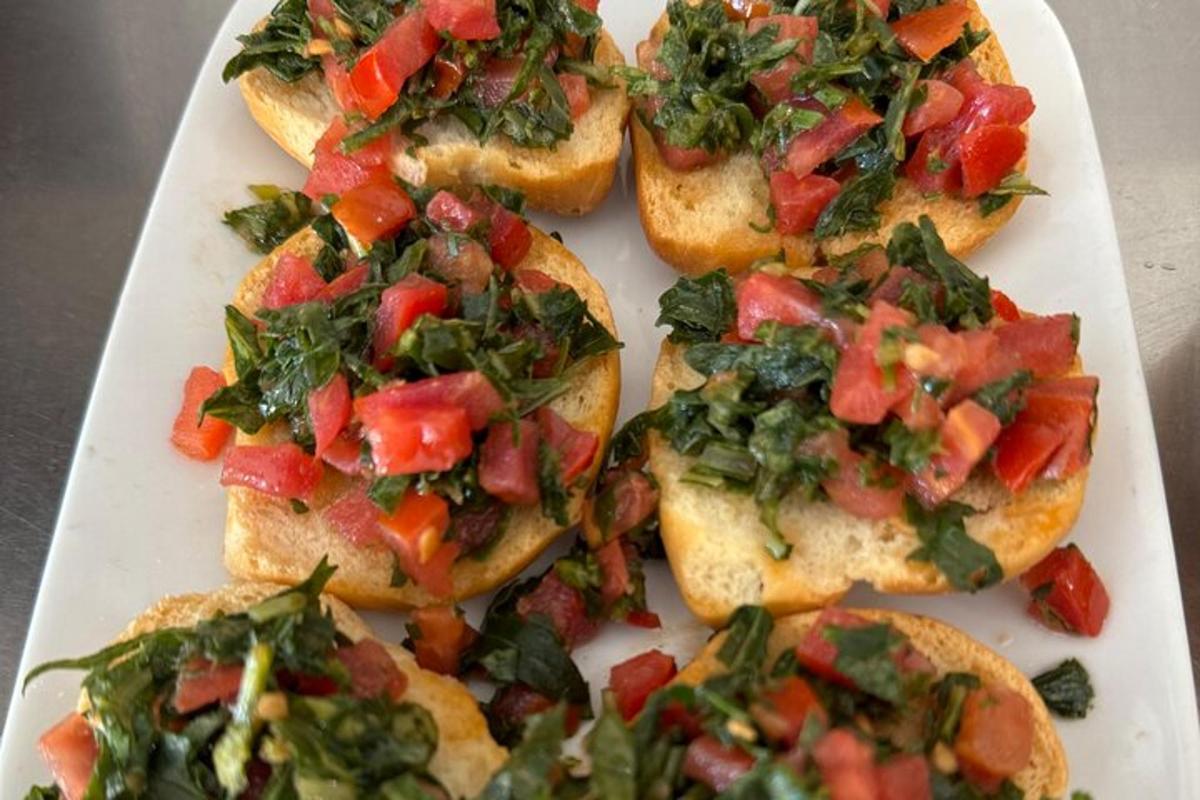 ein weißer Teller mit vier Sandwiches mit Tomaten und Salat