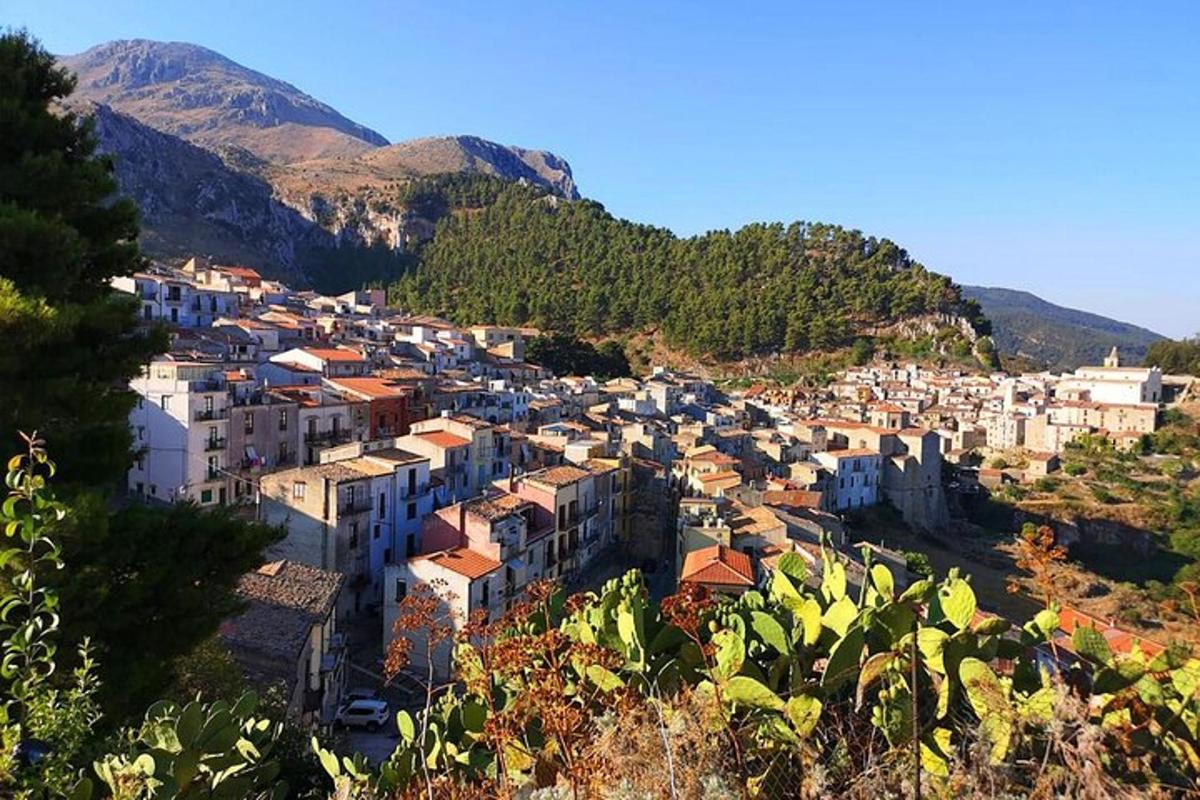 μια πόλη σε έναν λόφο με βουνά στο φόντο