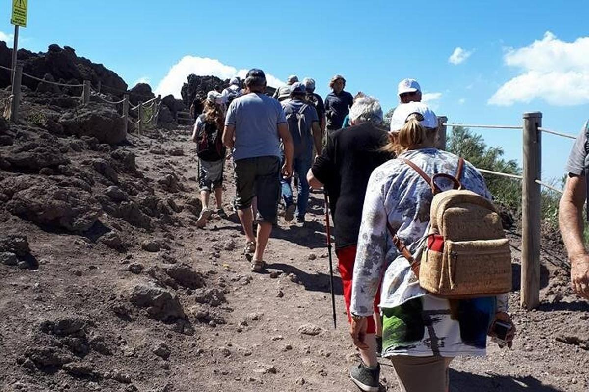 skupina lidí jdoucích po nezpevněné cestě