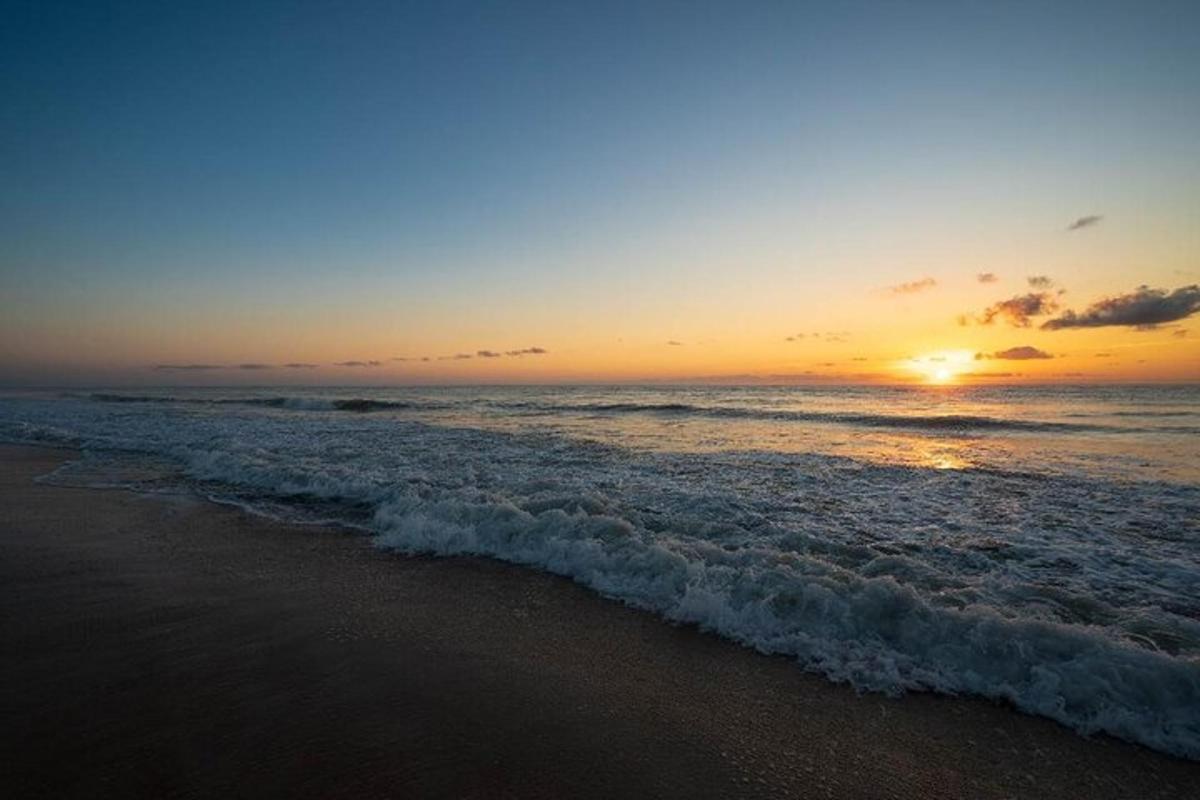 a sunset on the beach with the ocean