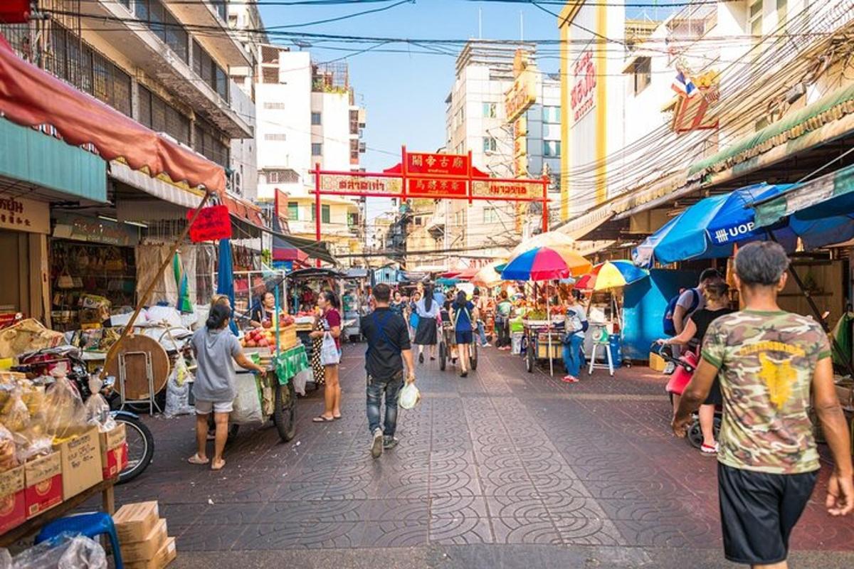 un gruppo di persone che camminano in un mercato all'aperto