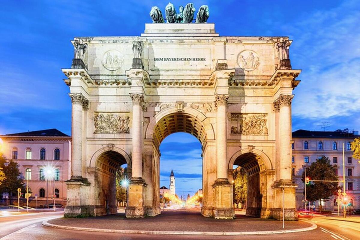 Un arco con una estatua delante de un edificio.