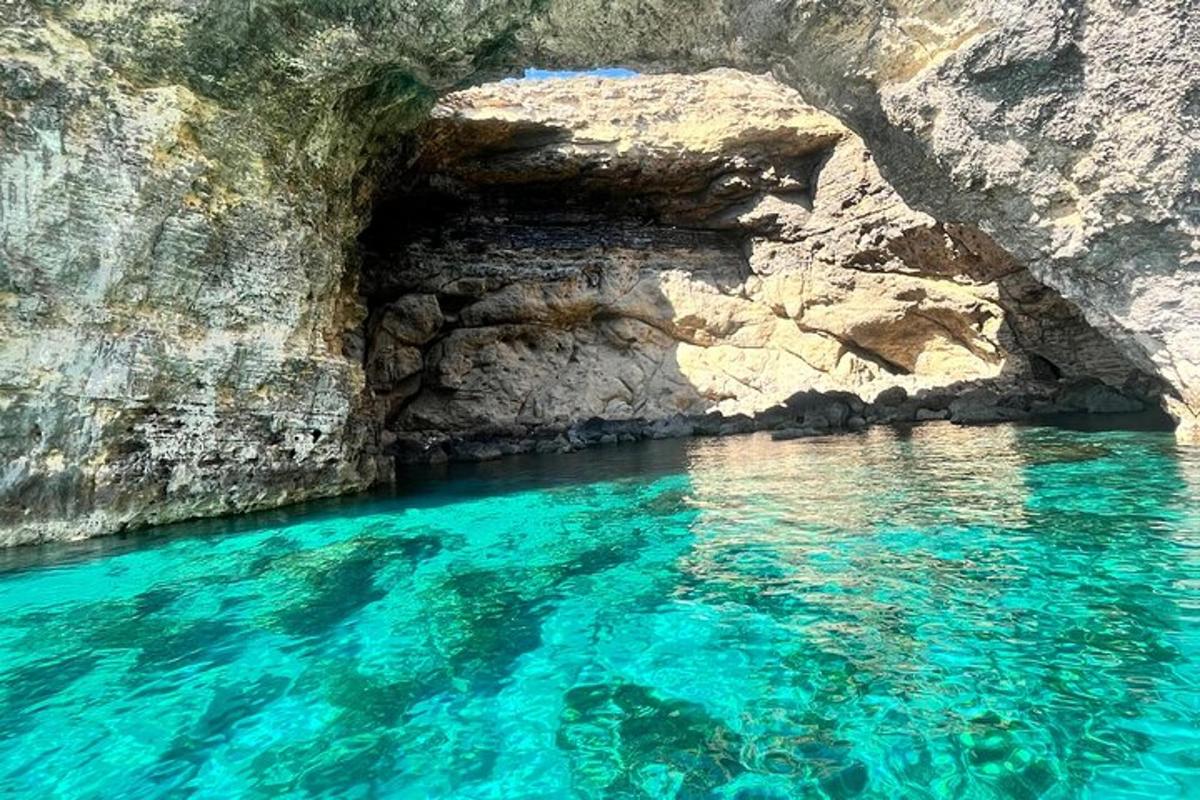 a blue pool of water next to a rocky cliff