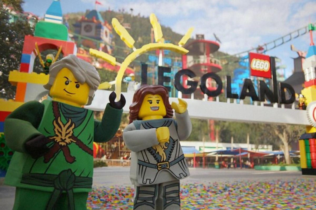 dva lego figurky stojící před zábavním parkem