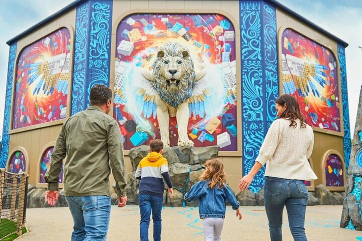 a family walking in front of a mural of a lion