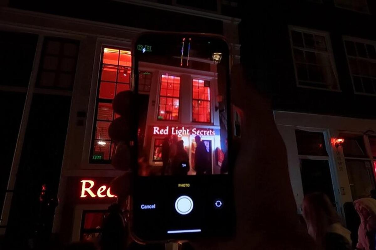 una persona sosteniendo un teléfono celular en la oscuridad
