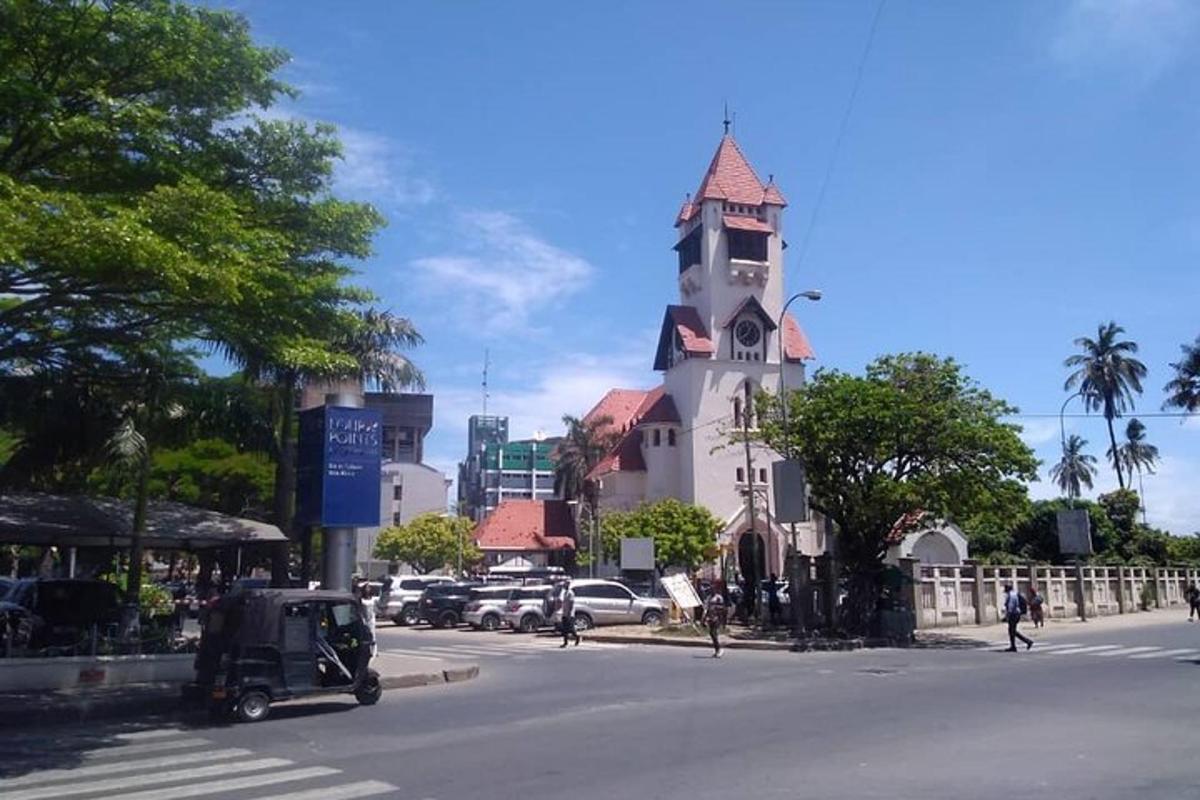 un edificio con una torre de reloj al costado de una calle
