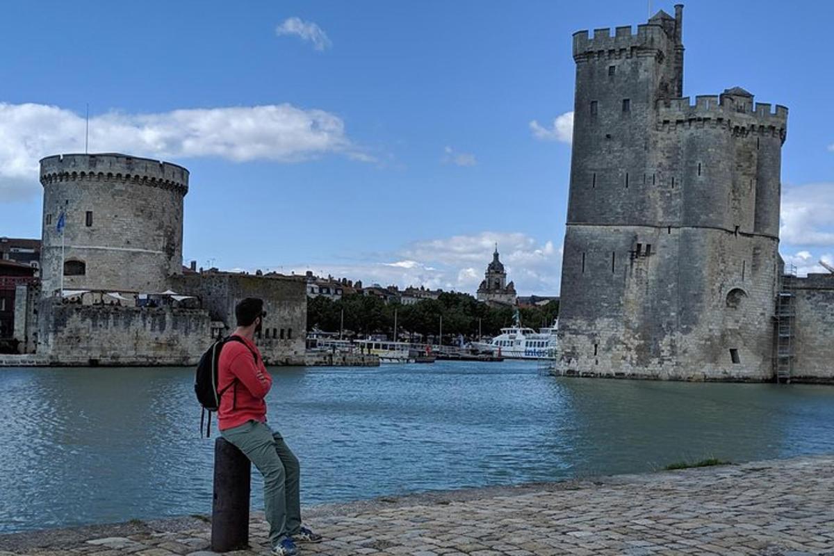 a man standing in front of a castle next to the water