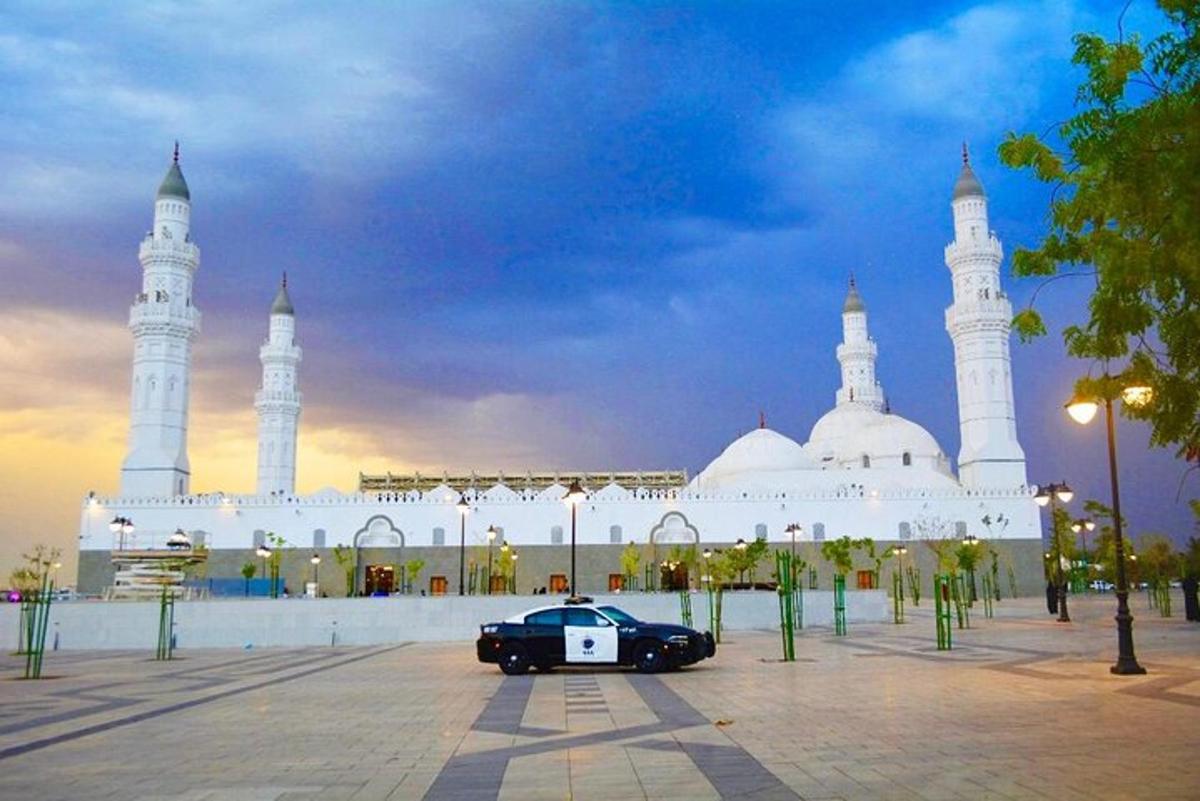 a black car parked in front of a mosque