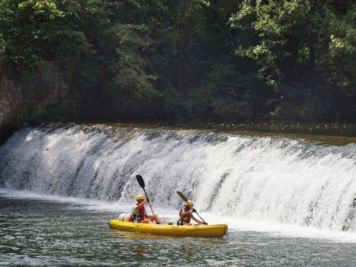 duas pessoas em um caiaque em frente a uma cachoeira