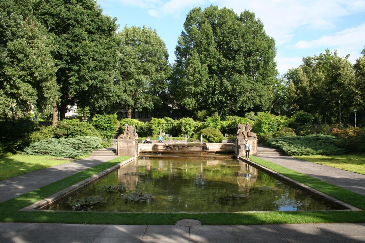 una fontana in un giardino con alberi sullo sfondo