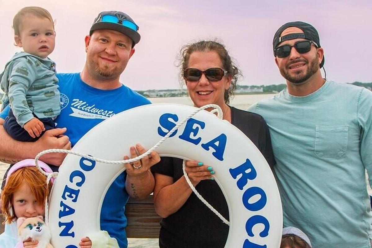 a family holding a sign that says sea open