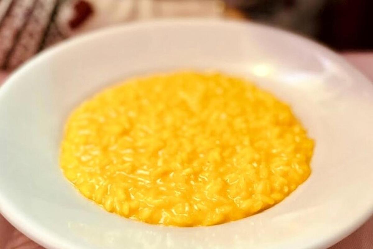 una ciotola bianca piena di cibo giallo su un tavolo