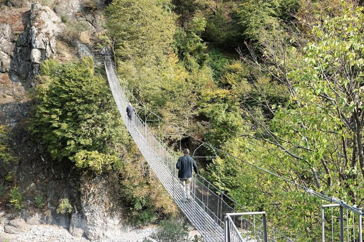 un uomo che cammina su un ponte sospeso sopra una montagna
