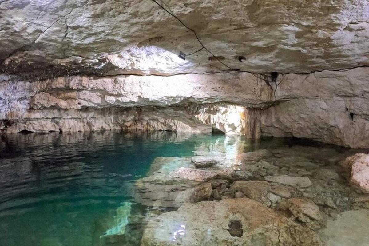 Una cueva con un estanque de agua en ella