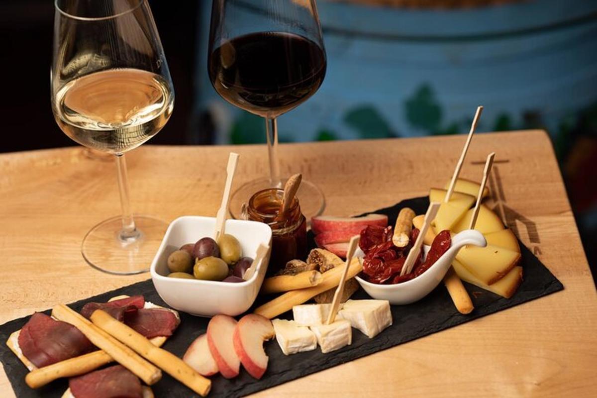 o farfurie cu brânzeturi și mezeluri și un pahar de vin