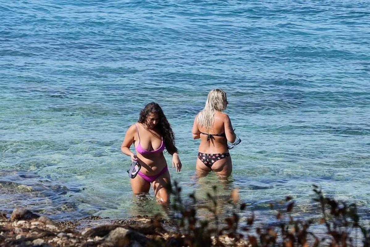 dalawang babaeng naka-bathing suit na naglalakad sa tubig
