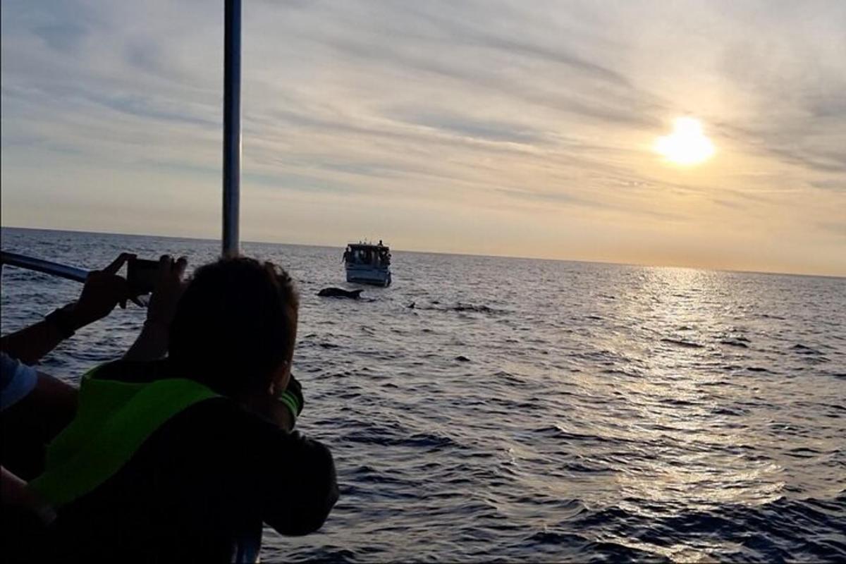 osoba fotografující loď v oceánu