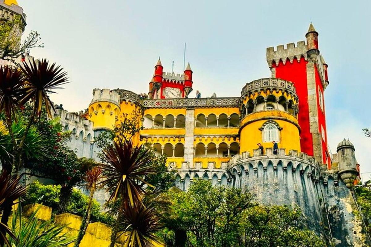 um castelo em uma colina com árvores na frente