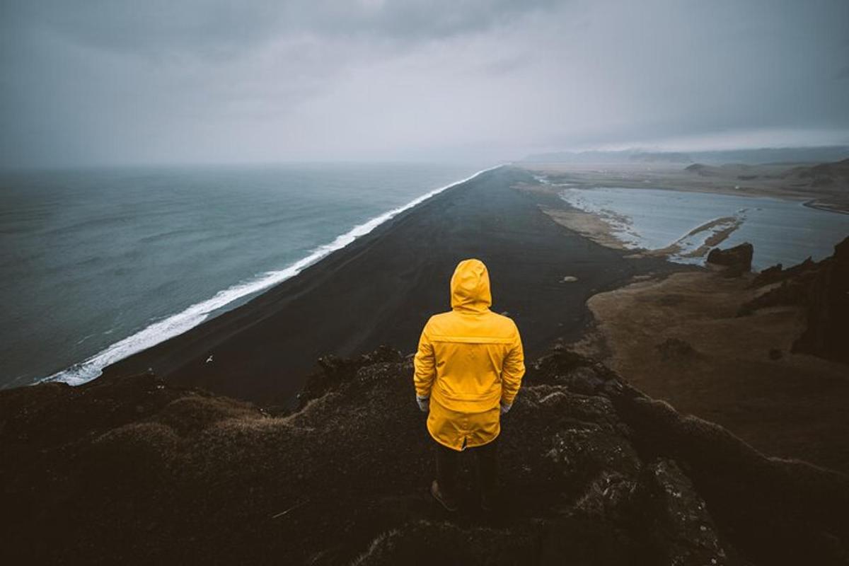a person standing on a mountain looking at the ocean