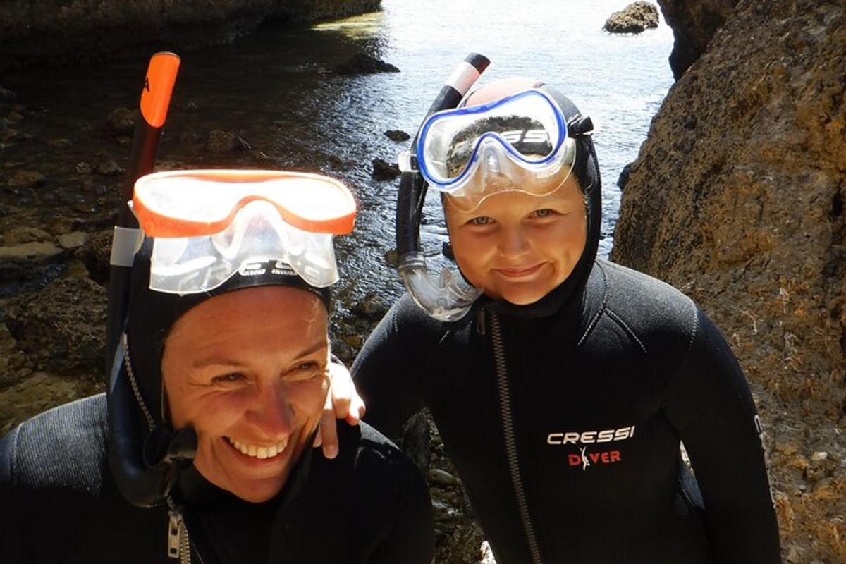 due persone che indossano attrezzatura da immersione in piedi accanto all'acqua
