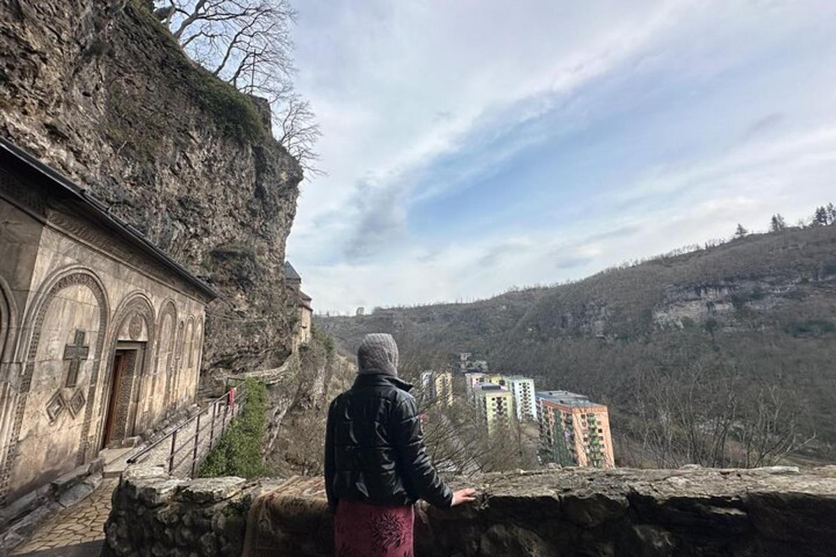 Una persona parada en un muro mirando una ciudad.
