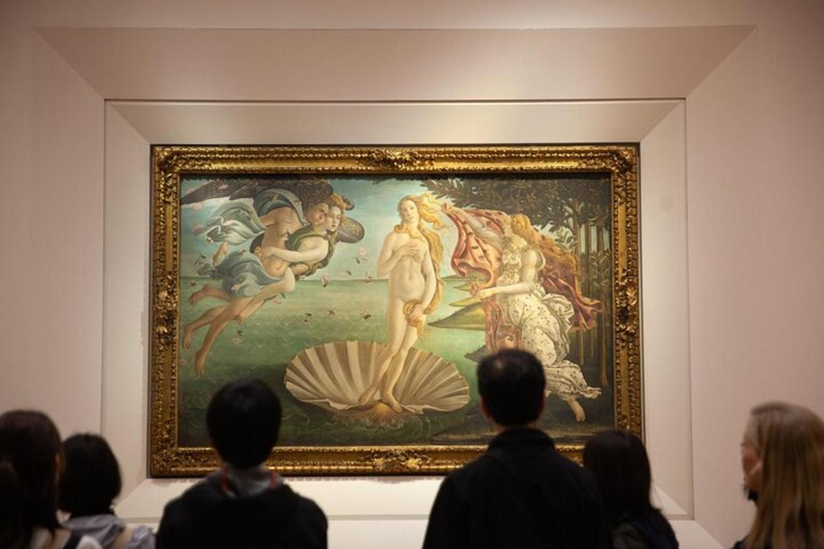 Un grupo de personas mirando una pintura en un museo.