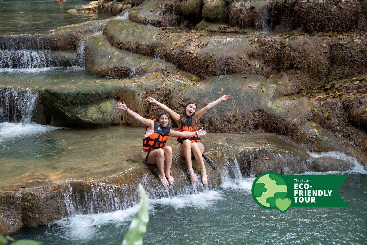 twee vrouwen zitten op een rots in een waterval