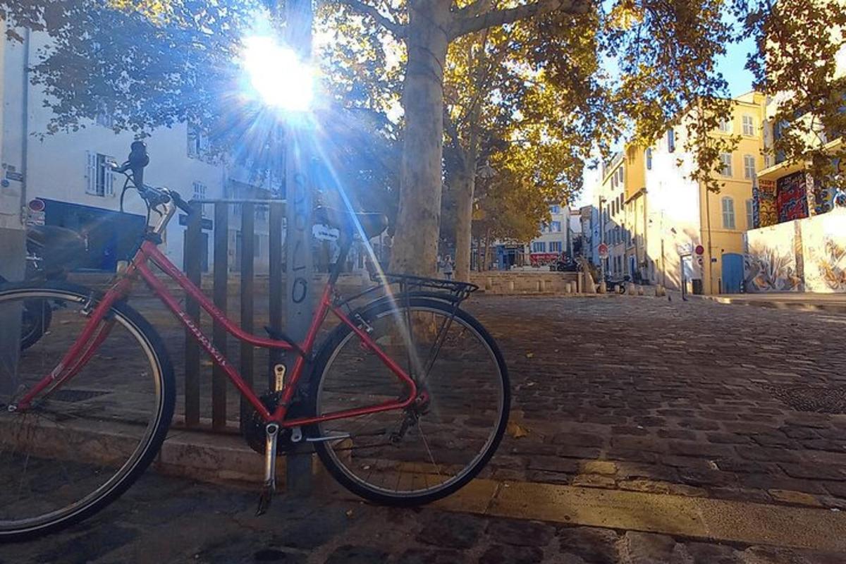 a red bike parked next to a fence