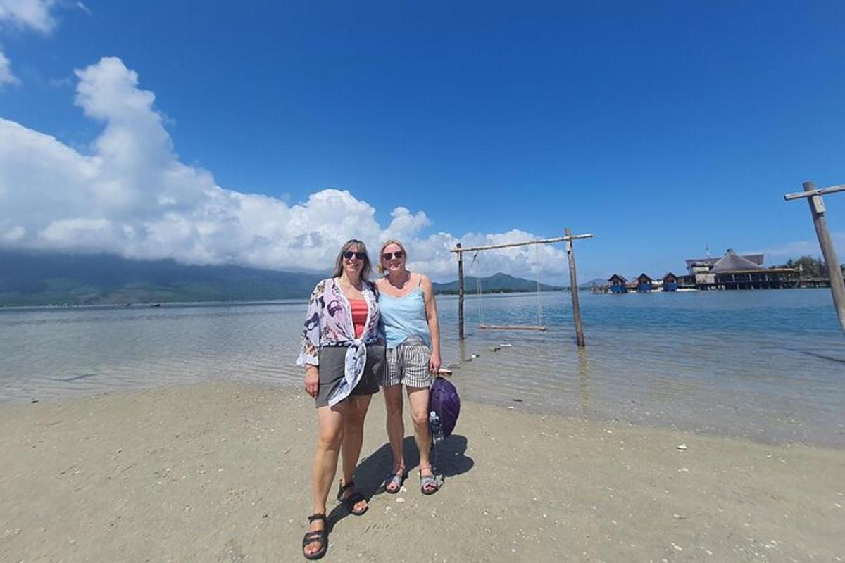 due donne in piedi sulla spiaggia vicino all'acqua