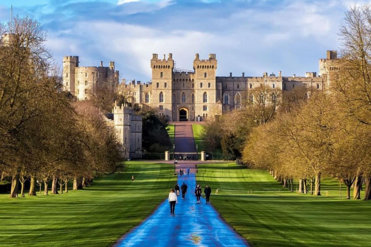 a castle with people walking down a path in front of it