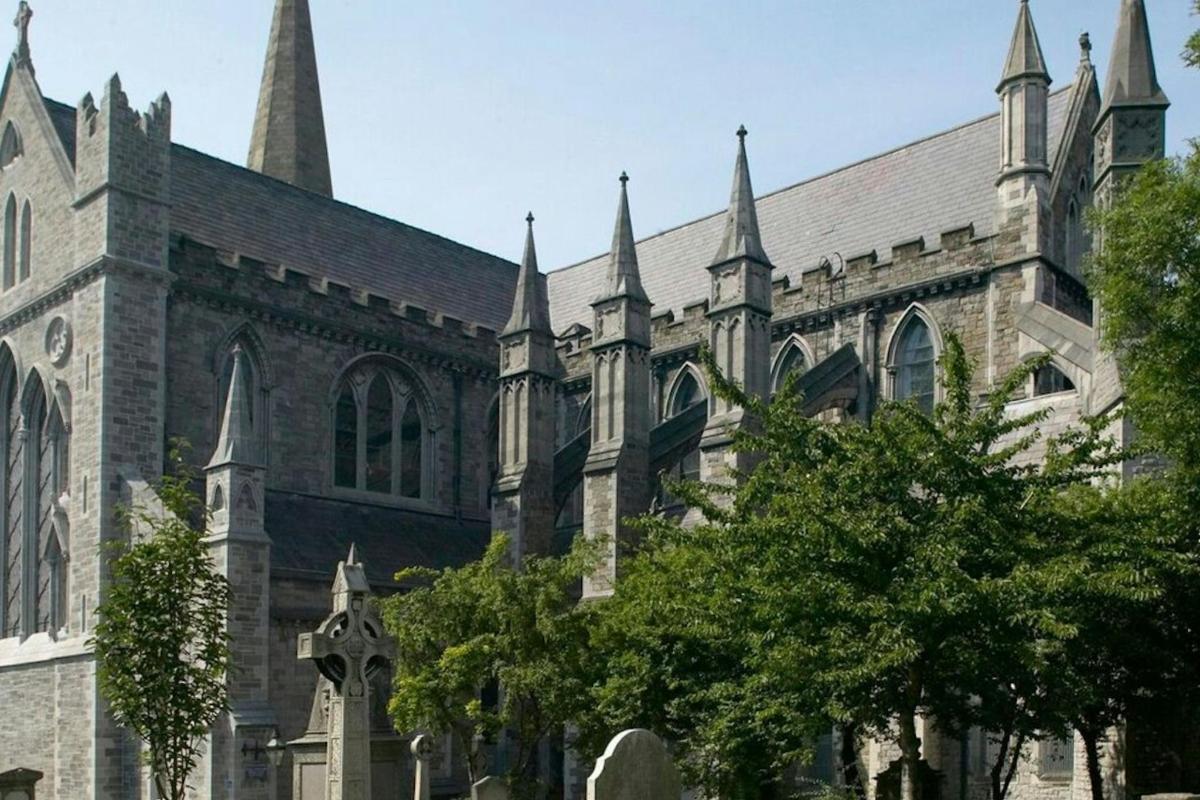 an old church with turrets and trees in front of it